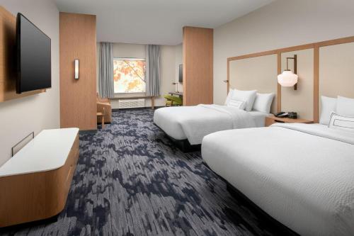 a hotel room with two beds and a flat screen tv at Fairfield Inn & Suites by Marriott Miami Airport West/Doral in Miami