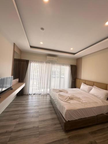 a bedroom with a large bed and a large window at Sleep At Airport in Nai Yang Beach