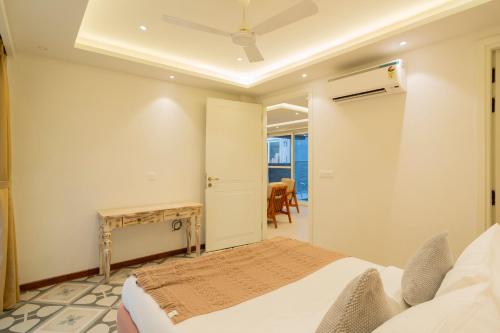 a bedroom with a bed and a table and chairs at ELIVAAS Solace Azure 4 BHK Villa with Pvt Pool in Calangute