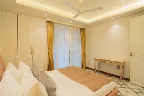 a bedroom with a bed and a window at ELIVAAS Solace Azure 4 BHK Villa with Pvt Pool in Calangute