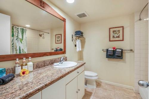 a bathroom with a sink and a toilet and a mirror at Islander on the Beach 343 in Kapaa
