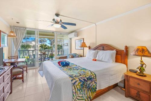 a bedroom with a bed and a desk and a window at Islander on the Beach 343 in Kapaa