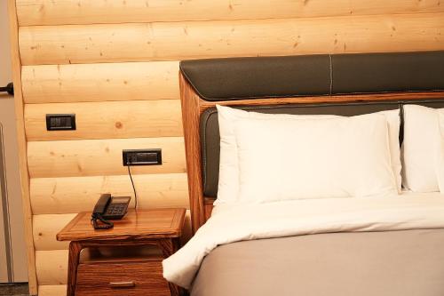 a bedroom with a bed and a phone on a table at Mounthree in Pʼambak