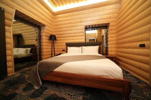 a bedroom with a bed in a log cabin at Mounthree in Pʼambak
