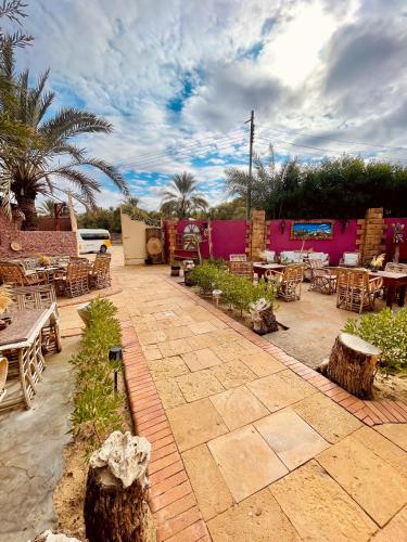 a patio with tables and chairs and tables at Panta Lodge Siwa بنتا لودج سيوة in Siwa