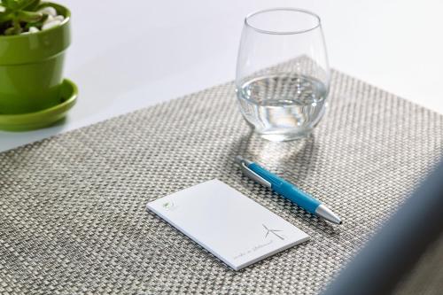 a pen and a paper on a table with a glass at Element Chandler Fashion Center in Chandler