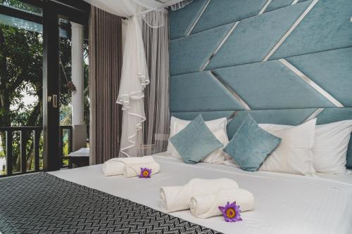 a bedroom with a bed with towels and pillows at River View Villas in Aluthgama
