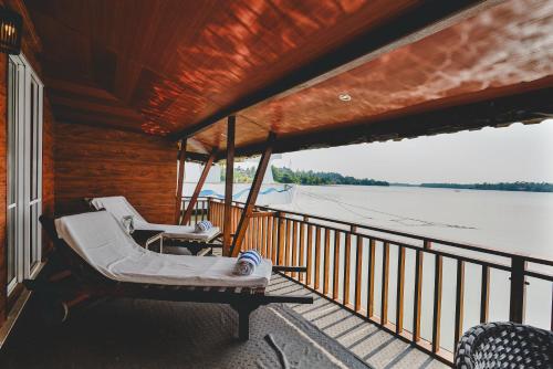 a porch with two lounge chairs on a boat at River View Villas in Aluthgama