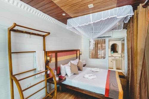 a bedroom with a large bed with a wooden ceiling at River View Villas in Aluthgama
