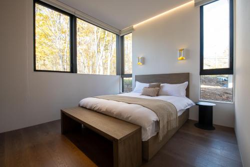 a bedroom with a large bed and windows at The Fount Niseko in Niseko