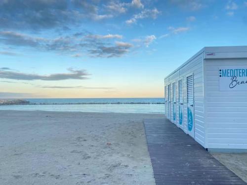 a building on the beach with the ocean in the background at Hotel Mediterraneo in Martinsicuro