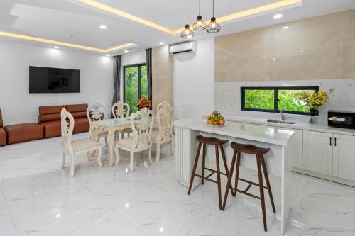 a kitchen and living room with a table and chairs at Langco Bay Retreat in Lang Co