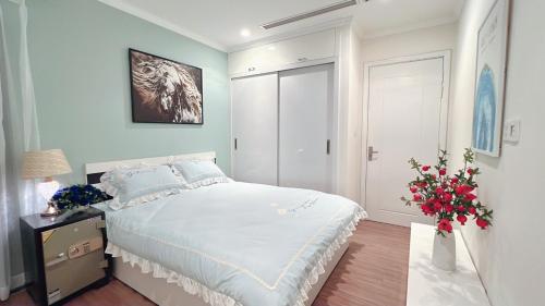 a bedroom with a large bed and a vase of flowers at VINHOME TIME CITY CĂN HỘ 2 PHÒNG NGỦ in Hanoi