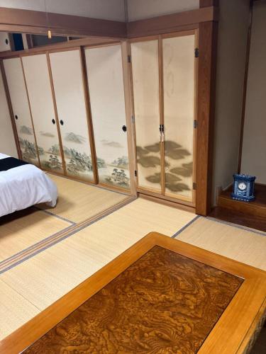 a bedroom with glass doors and a rug on the floor at Private Lodging KASE 五所川原 in Goshogawara