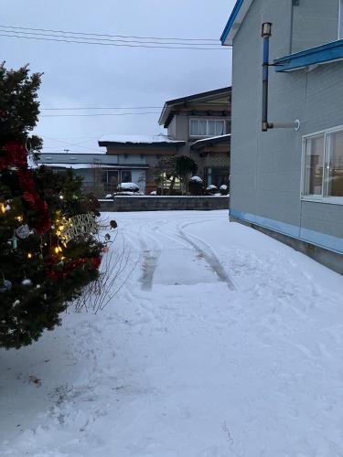 a driveway covered in snow next to a building at Private Lodging KASE 五所川原 in Goshogawara