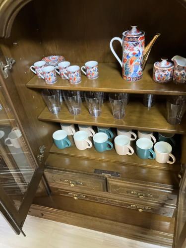 a shelf filled with cups and a bunch of mugs at Private Lodging KASE 五所川原 in Goshogawara