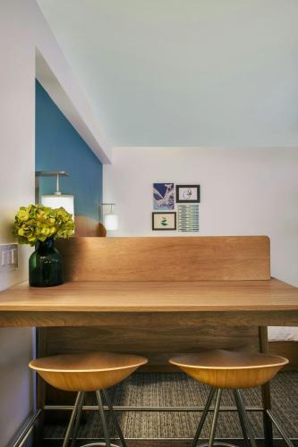 a table with two chairs and a vase of flowers at Element Hampton Peninsula Town Center in Hampton