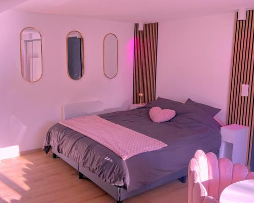 - une chambre avec un lit violet et des miroirs au mur dans l'établissement Pink Room by Loveroomeo, à Pontarlier