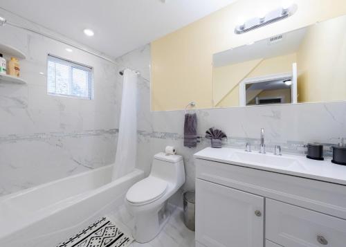 a white bathroom with a toilet and a sink at 233-3 - 4BR Boston - Peaceful Escape near Park Zoo in Boston