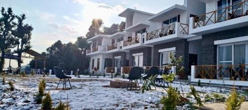 a group of chairs in front of a building at Maatidera Resort Kanatal The Boutique stay in the Lap of Himalayas in Kanatal