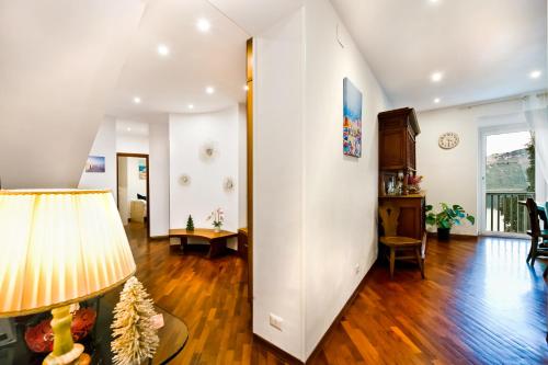 a living room with wooden floors and a white wall at la vista sul lago in Castel Gandolfo