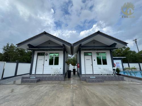 a building with white doors and white chairs at The Gelam House in Kampong Telaga Papan