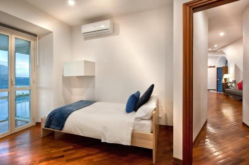 a bedroom with a bed and a large window at la vista sul lago in Castel Gandolfo