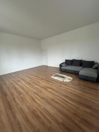 a living room with a couch and a wooden floor at The White House in Rumbula