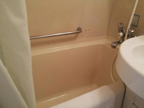 a bathroom with a tub and a toilet and a sink at Uwajima Regent Hotel in Uwajima