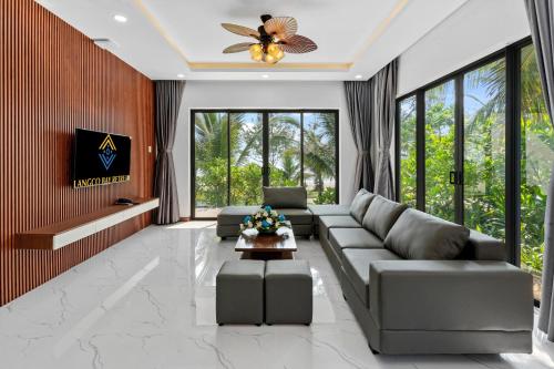 a living room with a couch and a ceiling fan at Langco Bay Retreat in Lang Co