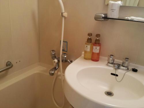 a bathroom with a sink and a bath tub and a sink at Uwajima Regent Hotel in Uwajima