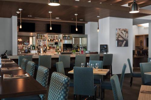 a restaurant with tables and chairs and a bar at Four Points by Sheraton Fort Lauderdale Airport/Cruise Port in Fort Lauderdale