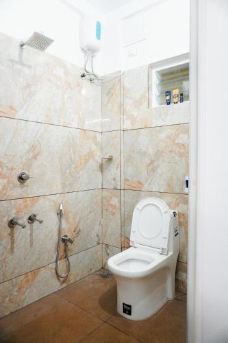 a bathroom with a toilet and a shower at Wave in Cochin