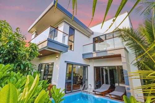 a villa with a swimming pool and a house at Langco Bay Retreat in Lang Co