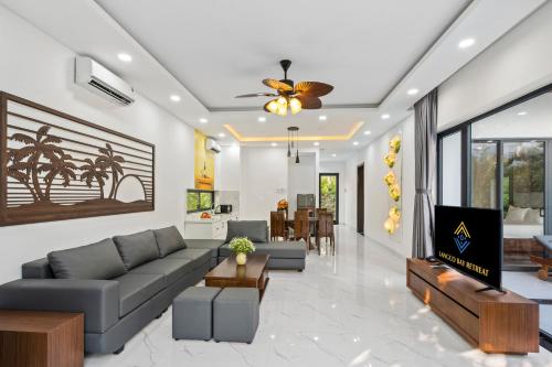a living room with a couch and a tv at Langco Bay Retreat in Lang Co