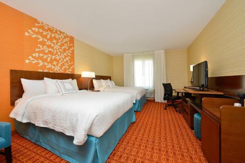 a hotel room with two beds and a desk and a television at Fairfield Inn & Suites by Marriott Elmira Corning in Horseheads