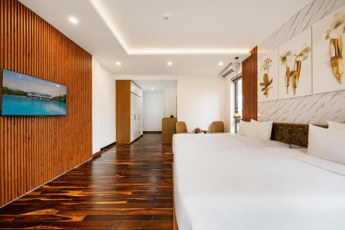 a hotel room with a bed and a tv on a wall at Langco Bay Retreat in Lang Co