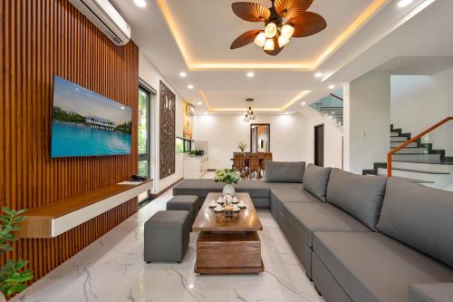 a living room with a couch and a tv at Langco Bay Retreat in Lang Co