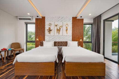 two beds in a room with a table and chairs at Langco Bay Retreat in Lang Co