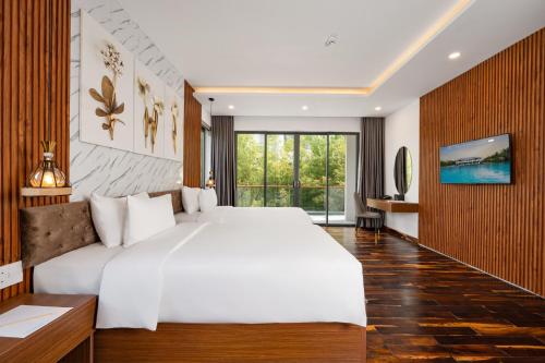 a bedroom with a large white bed and a large window at Langco Bay Retreat in Lang Co