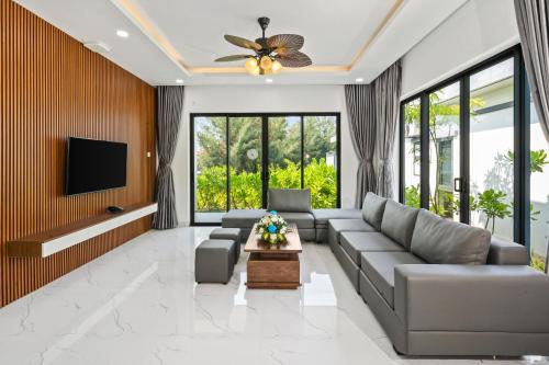 a living room with a couch and a tv at Langco Bay Retreat in Lang Co