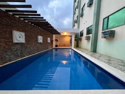 a large blue swimming pool next to a building at People's Condo Atria in Iloilo City