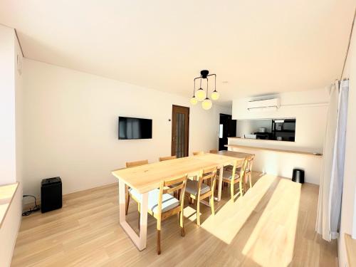 a dining room with a wooden table and chairs at Stunning Resort Villa! Great Access to Niseko and Rusutsu! in Kimobetsu