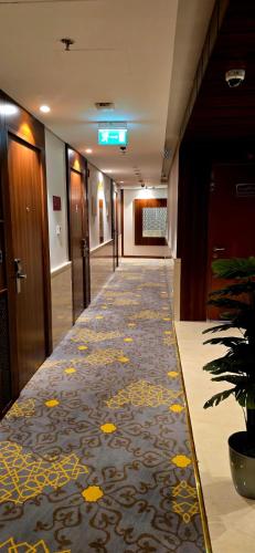 a hallway of an office building with a carpet at Maysan Rehab Al Mysk Hotel in Al Madinah