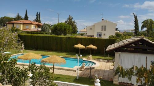 a swimming pool with umbrellas in a yard at villa molinos in Otura
