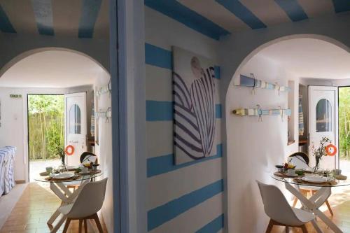 een eetkamer met 2 tafels en 2 spiegels bij Blue Marina in Sivota