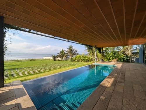an outdoor swimming pool with a view of the ocean at Ira Kabini by Luxunlock Private Villas in Antarasante