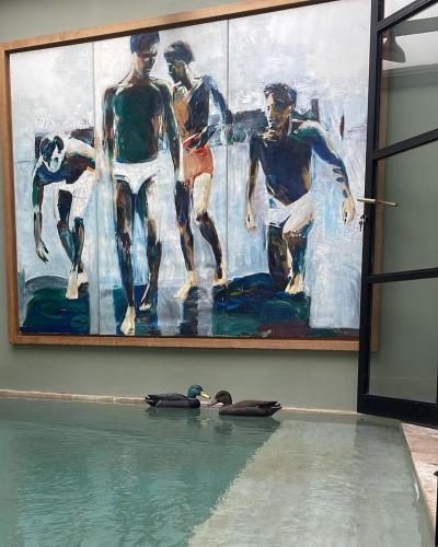 a duck swimming in a pool in front of a painting at Villa Augustine in Tangier