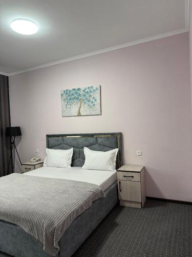 a bedroom with a large bed with white pillows at Shygys_hotel in Aktau