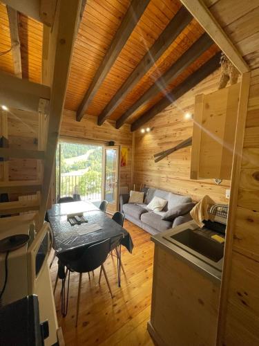 - une cuisine et un salon avec une table dans une cabine dans l'établissement Appartement secteur cambre d’aze 200m des pistes, à Saint-Pierre-dels-Forcats